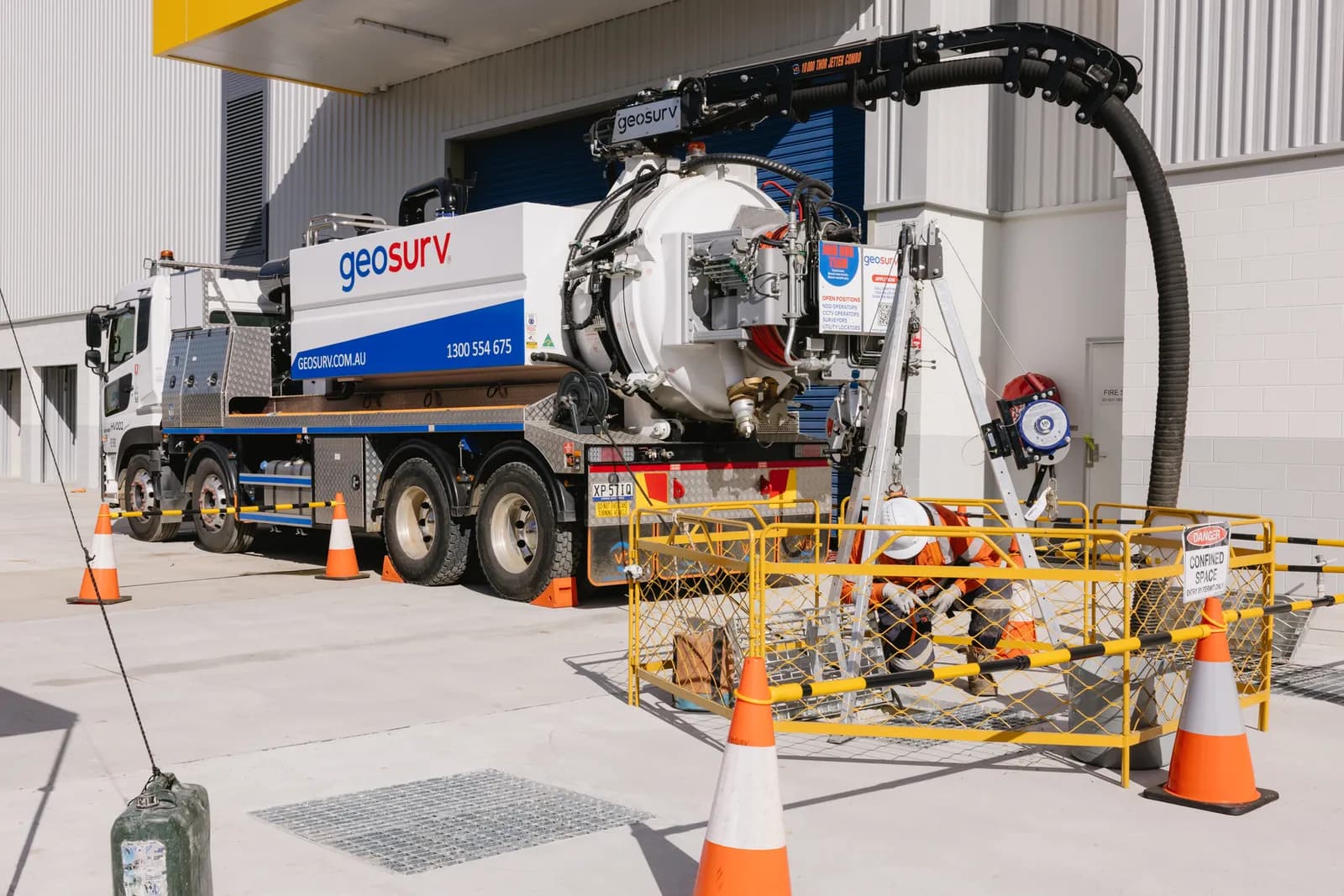 Geosurv operator high-pressure jetting a drain to clear blockages and debris