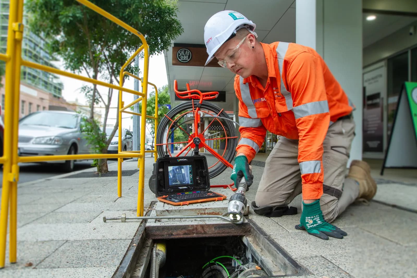 Geosurv operator running a push-rod camera inspection on a small-diameter line