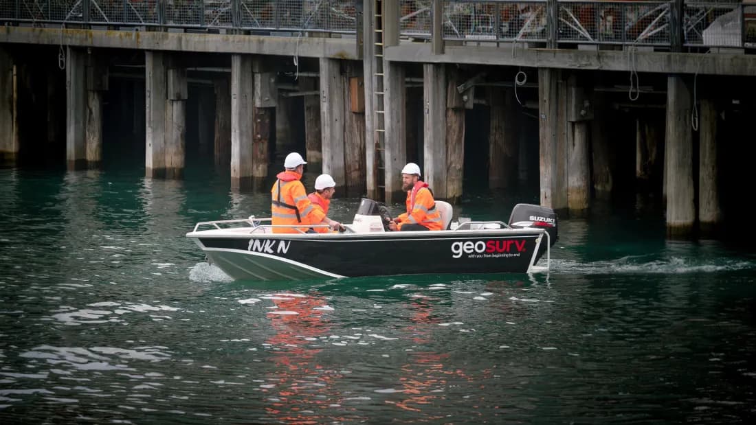 Geosurv crew in a survey vessel working beneath a Sydney wharf