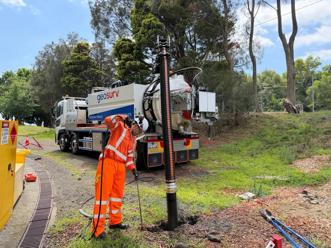 Geosurv vacuum excavation truck on site with a technician operating the suction boom